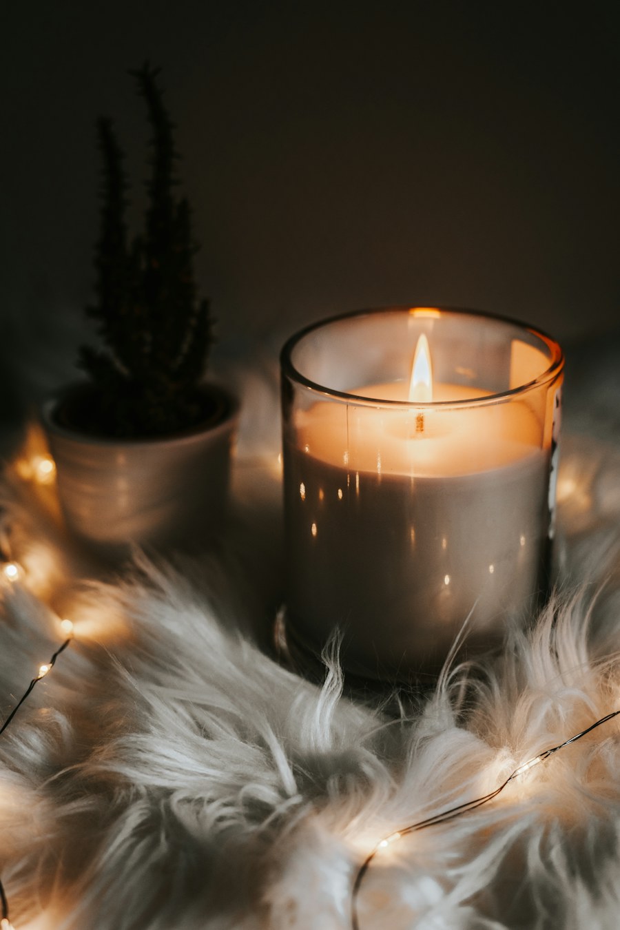 A candle glowing in an amber glass vessel